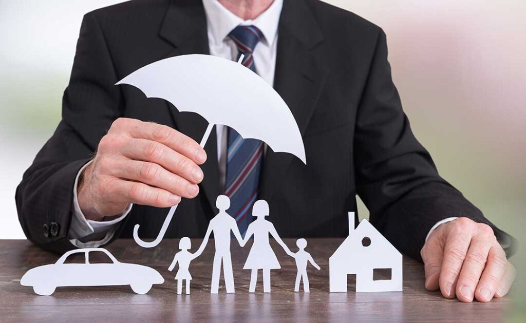 A couple reviews life insurance documents and a household budget at a kitchen table.